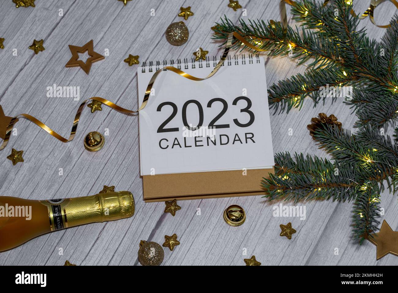 Neujahrskalender 2023 mit Glitzer, Konfetti und Golddekorationen und Champagnerflasche Stockfoto