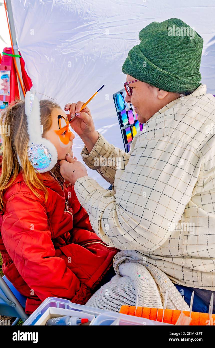 Beim alljährlichen Celtic Music Festival und den Scottish Highland Games am 13. November 2022 in Gulfport, Mississippi, malt eine Frau das Gesicht eines Kindes. Stockfoto