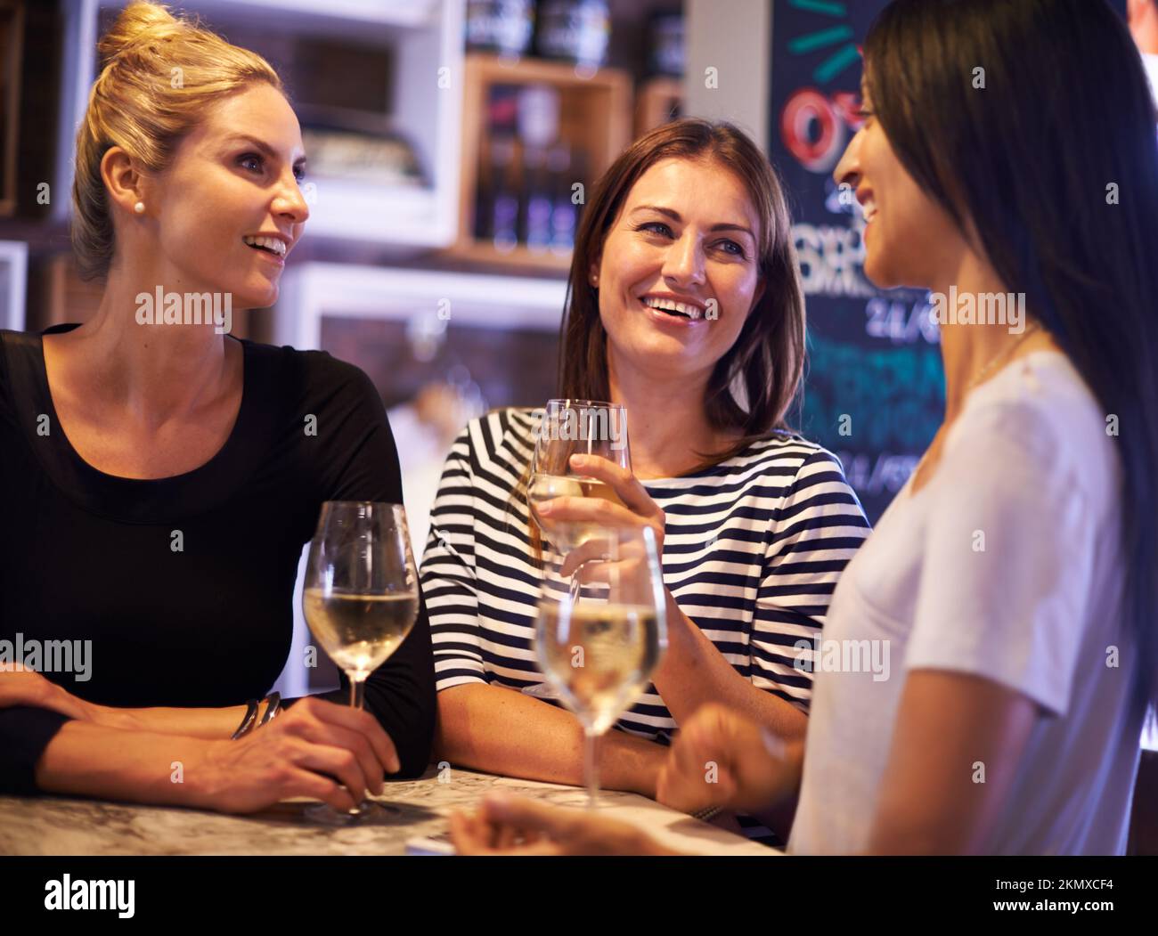 Es gibt keinen Mädchenabend ohne die Mädchen. Eine kurze Aufnahme von drei Frauen, die sich in einem Restaurant treffen. Stockfoto