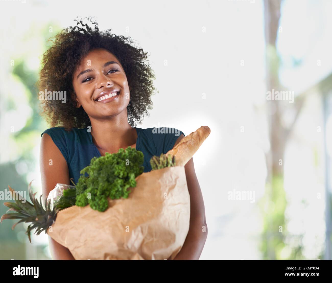 Alles, was sie für ihre neue und gesündere Ernährung braucht. Eine attraktive junge Frau mit einer Einkaufstasche. Stockfoto
