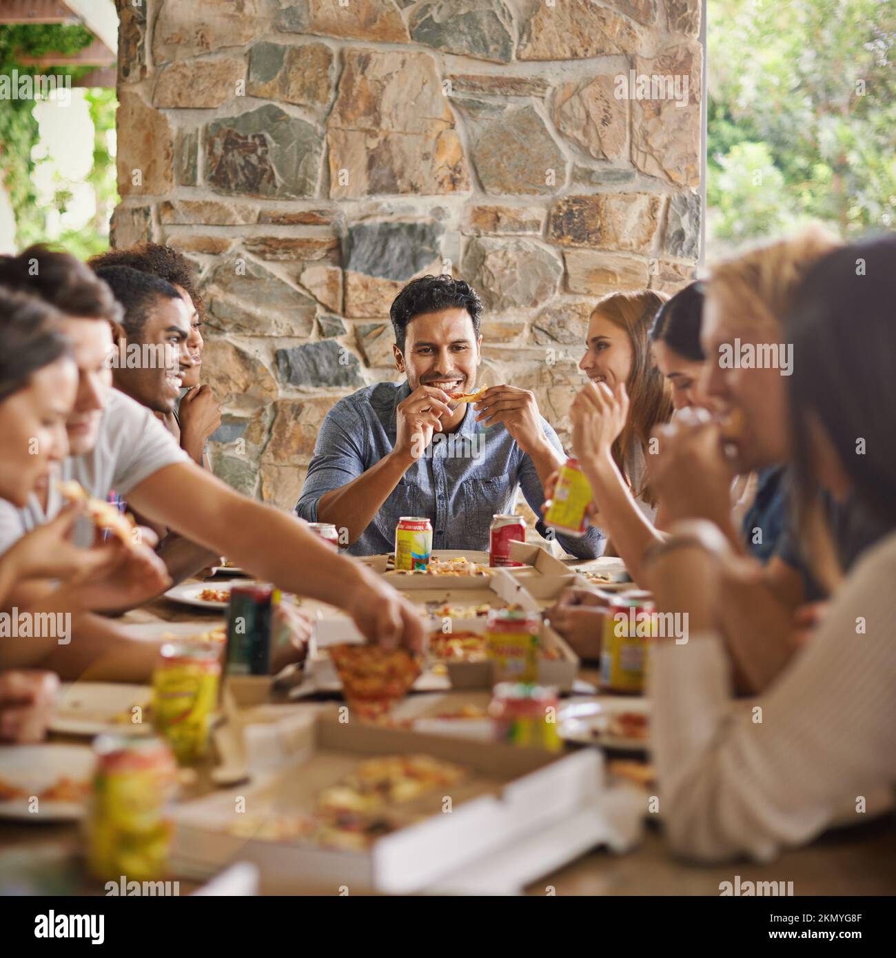 Gutes Essen, tolle Gesellschaft. Eine Gruppe von Freunden, die zusammen Pizza essen. Stockfoto