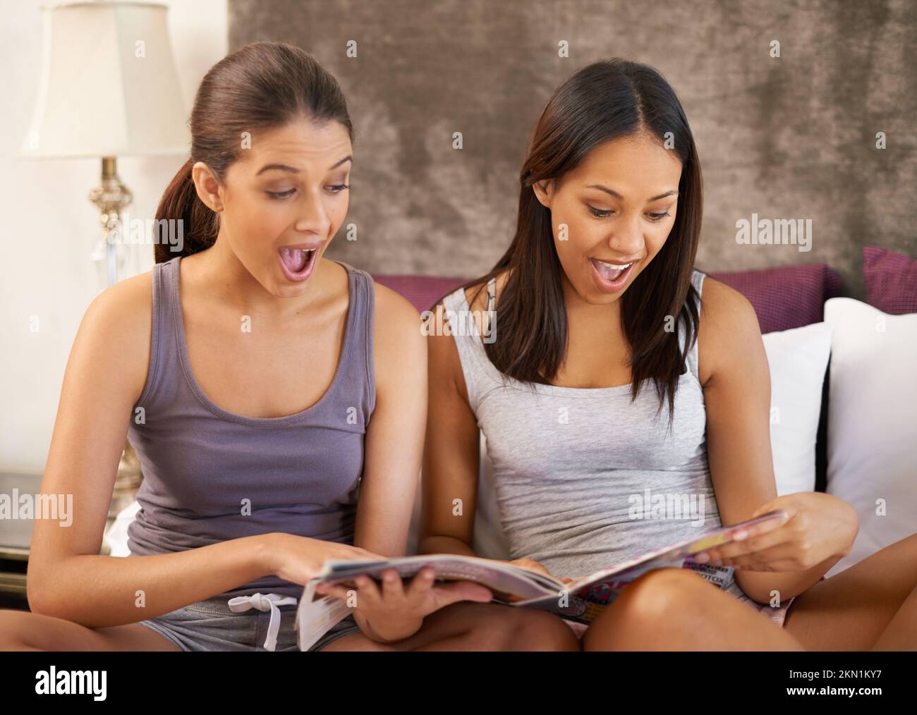 Wow, das war eine Überraschung... zwei Freunde, die Zeitschriften durchstöberten, während sie zusammen waren. Stockfoto