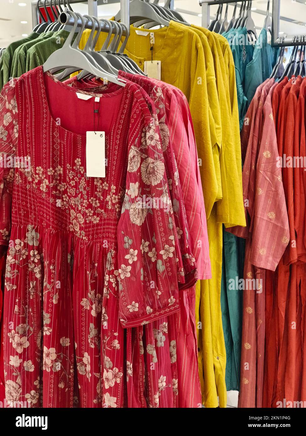 Legere Damenbekleidung in einer Boutique, Kleidung mit einer Auswahl an Damenmode, bunte Damenkleider auf Kleiderbügeln in einem Einzelhandelsgeschäft in Indien. Stockfoto