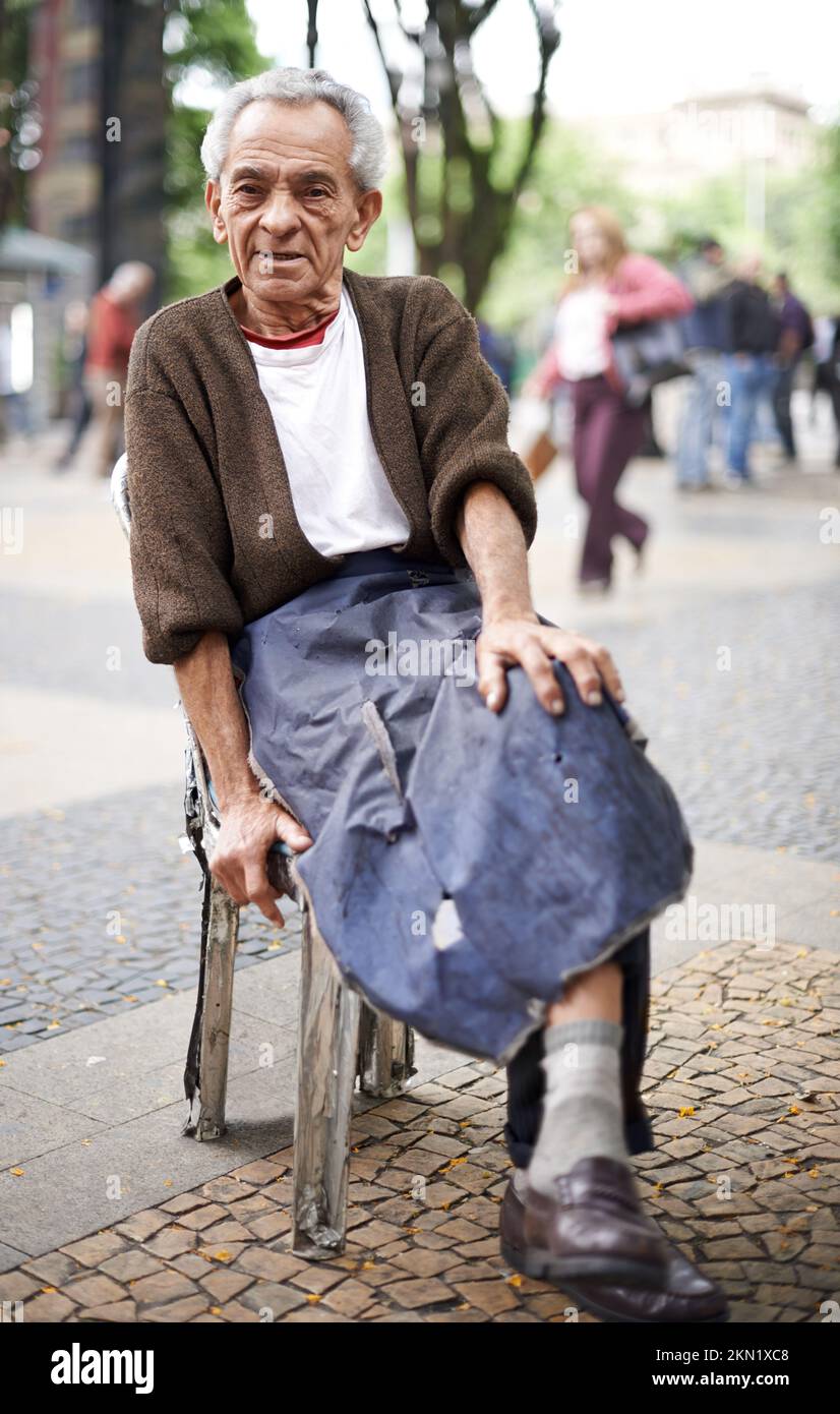Du machst das Beste aus dem Leben. Ein alter Mann, der draußen sitzt. Stockfoto