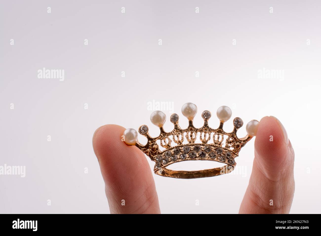 Goldene Krone-Farbmodell mit Perlen auf weißem Hintergrund Stockfoto