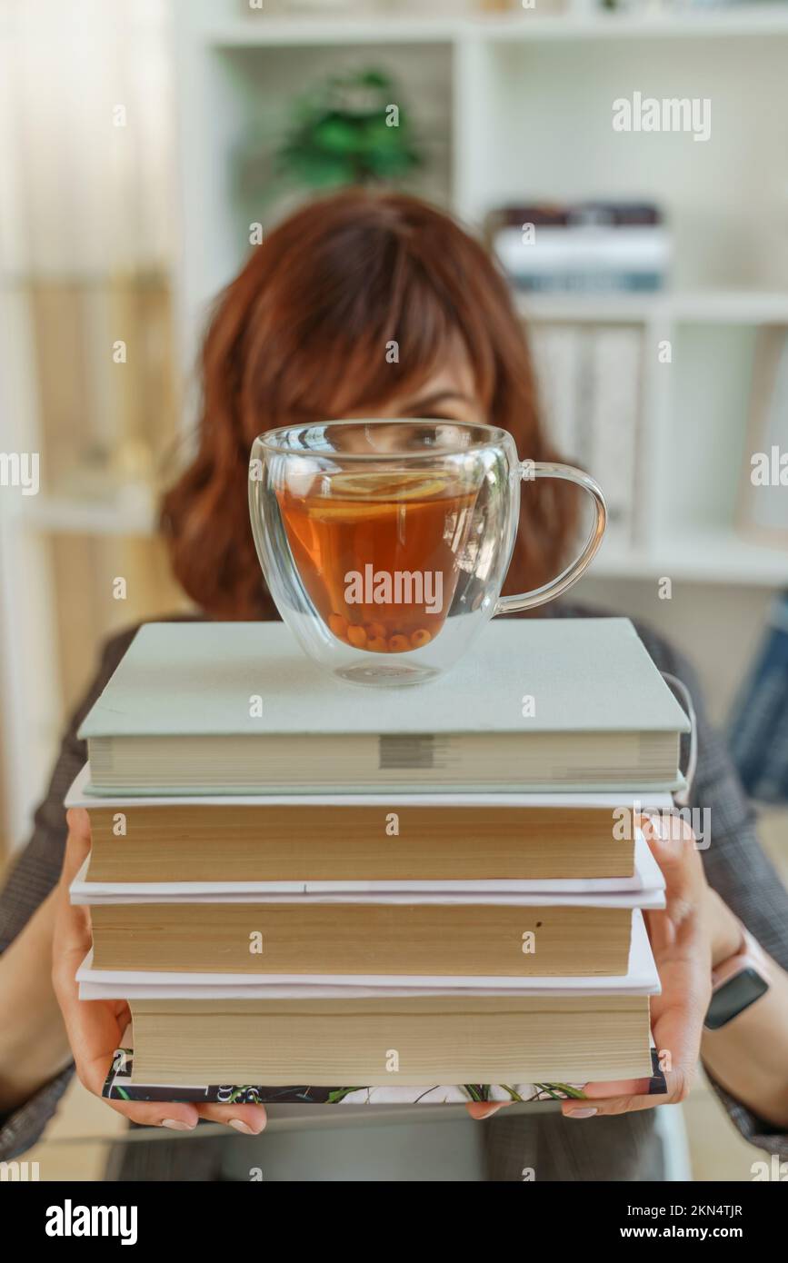 Langweiliges junges Studentenmädchen mit Büchern Stockfoto