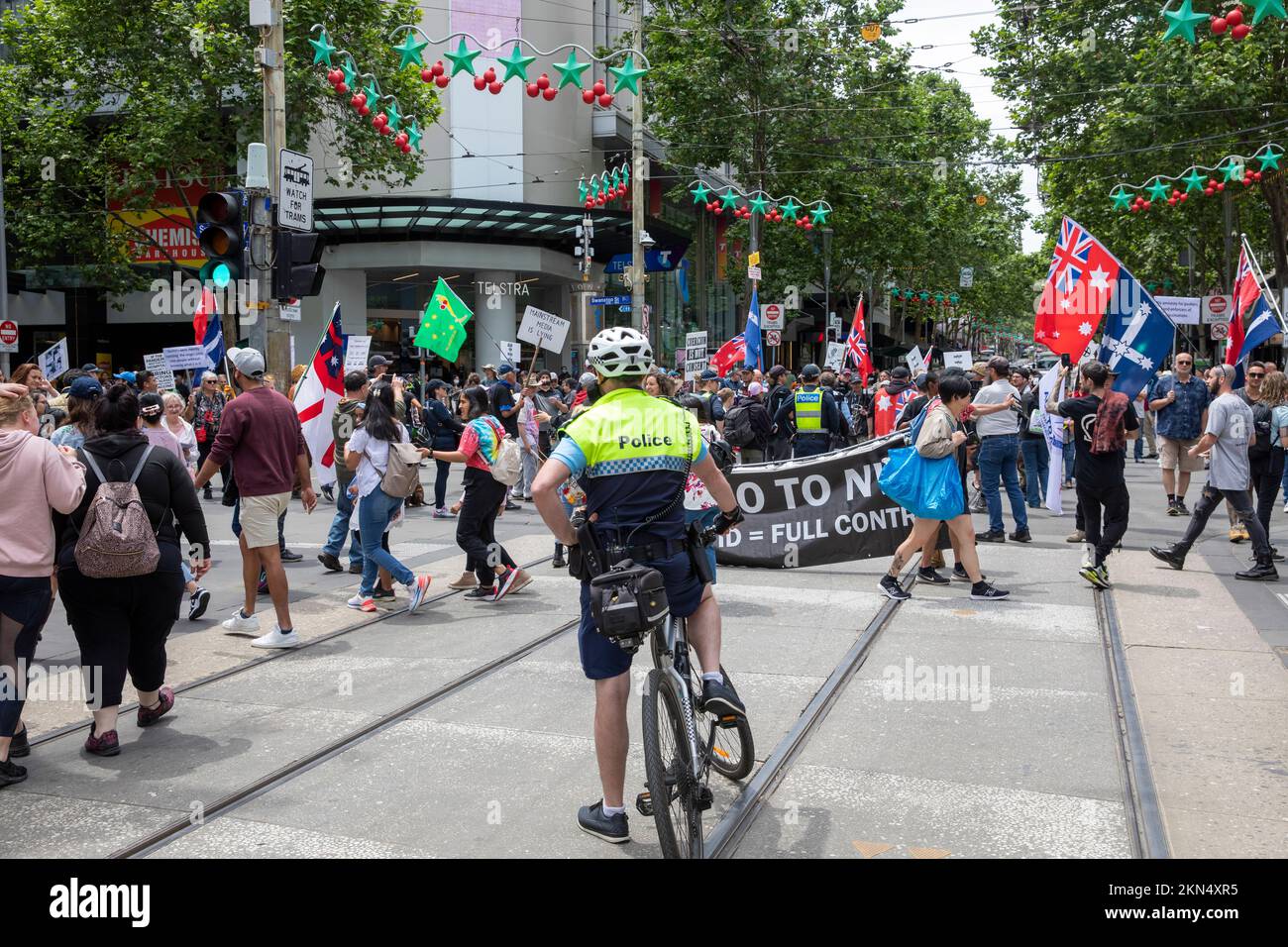 Polizeibeamter Melbourne auf einem Fahrrad Teil der Polizeioperation Überwachung Anti-Impfstoff-Protest in Melbourne City Centre, Victoria, Australien Stockfoto