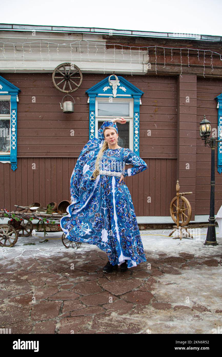 Russisches Mädchen in russischen Nationalkostümen des Winters in einem Dorf Stockfoto