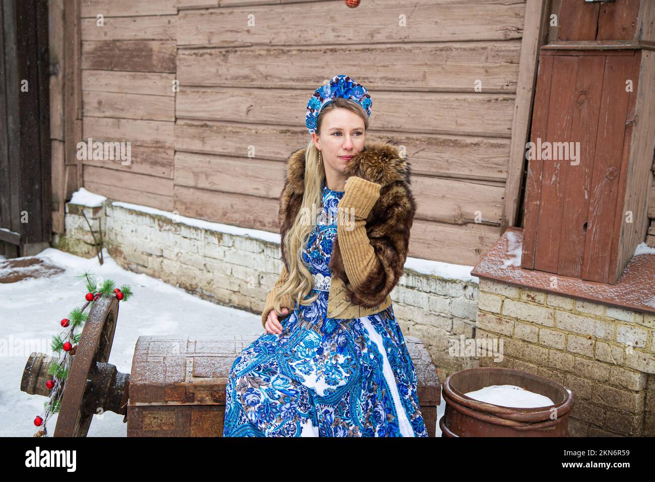 Russisches Mädchen in russischen Nationalkostümen des Winters in einem Dorf Stockfoto