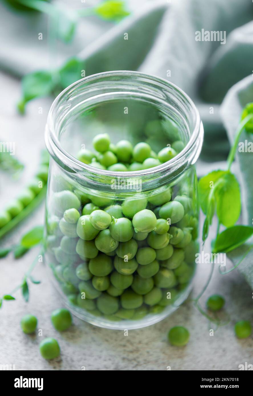 Glas mit jungen, frischen, saftigen Hülsen aus grünen Erbsen. Gesunde Bio-Lebensmittel. Stockfoto
