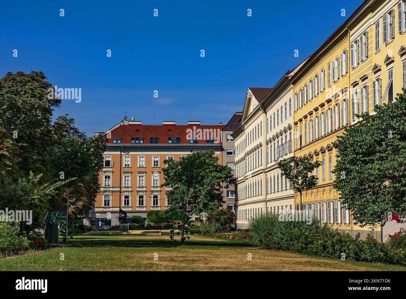 Blick auf den Brunnen des Rosariums, den Park und die umliegenden Gebäude in Graz, Österreich Stockfoto