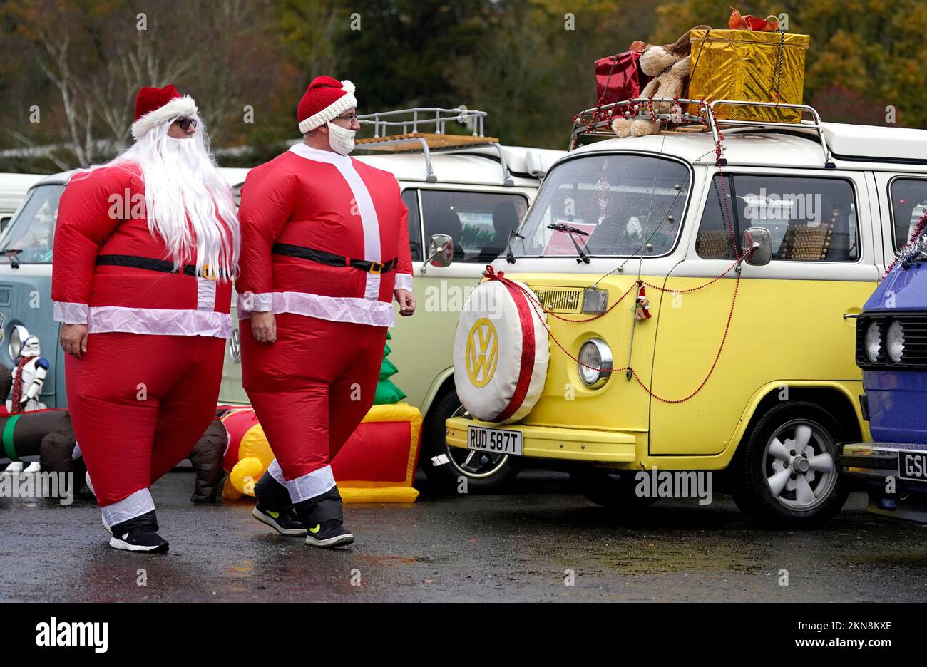 Teilnehmer, die als Weihnachtsmann verkleidet sind, besichtigen andere VW-Wohnwagen mit Weihnachtsdekorationen vor dem New Forest VW Santa Run im Beaulieu Motor Museum. Foto: Sonntag, 27. November 2022. Stockfoto