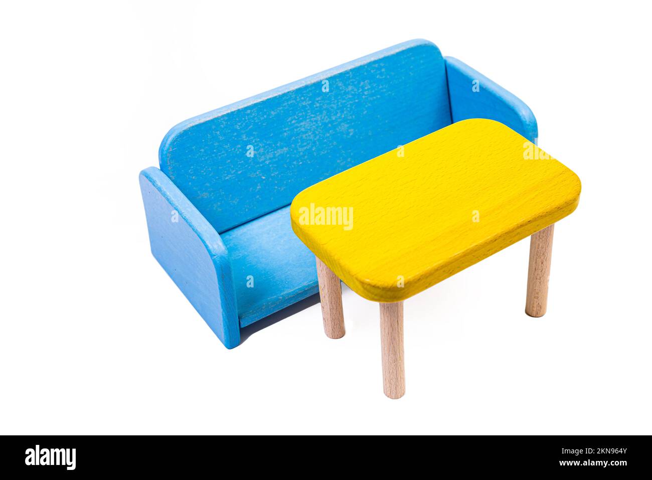 Ein blauer Spielzeugstuhl aus Holz, ein Sofa, zwei Stühle mit einem Tisch, ein gelber Tisch, blaue gepolsterte Holzstühle. Gelbe Lampe auf isoliertem weißem Hintergrund für Stockfoto