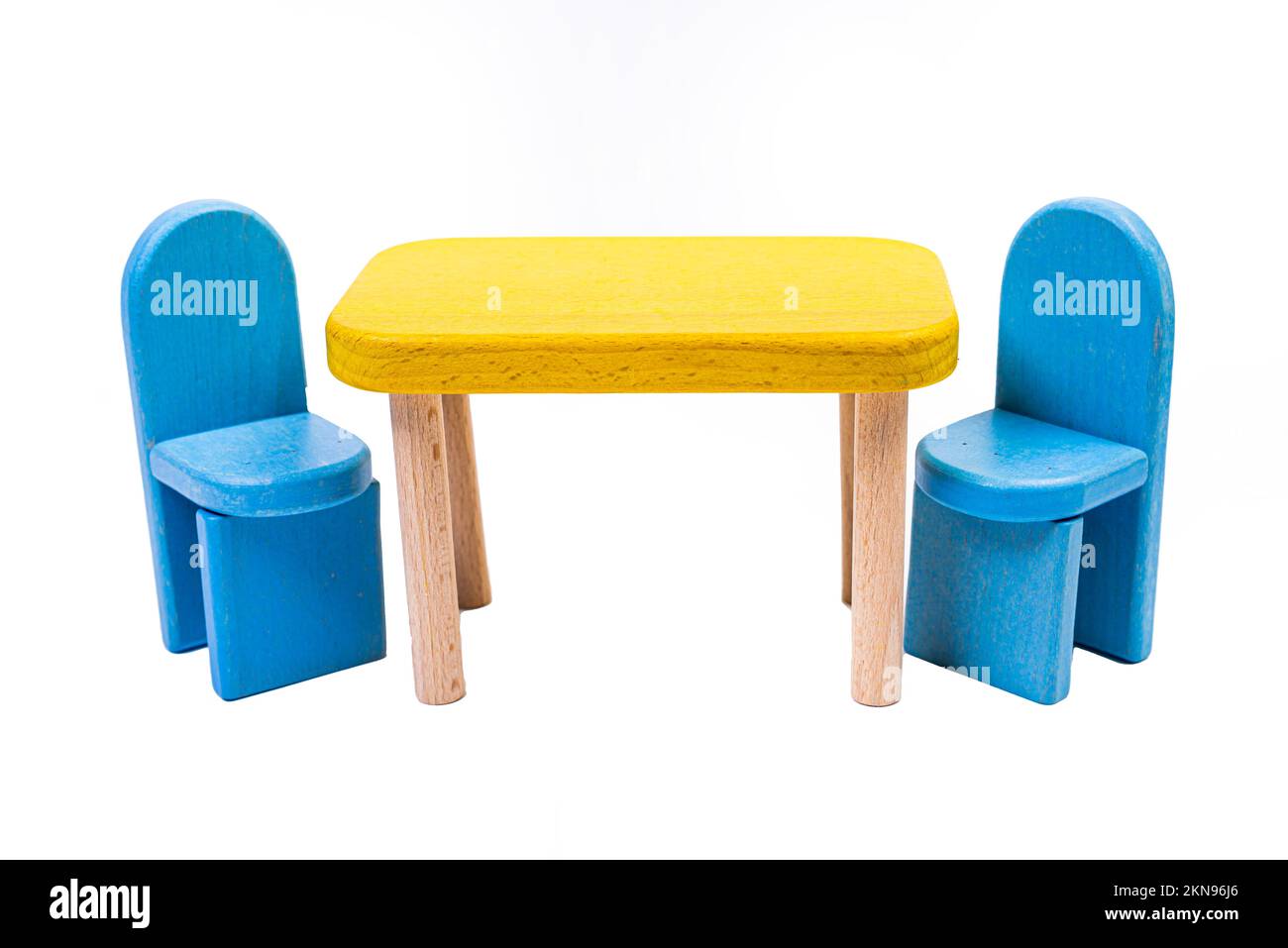 Ein blauer Spielzeugstuhl aus Holz, ein Sofa, zwei Stühle mit einem Tisch, ein gelber Tisch, blaue gepolsterte Holzstühle. Gelbe Lampe auf isoliertem weißem Hintergrund für Stockfoto