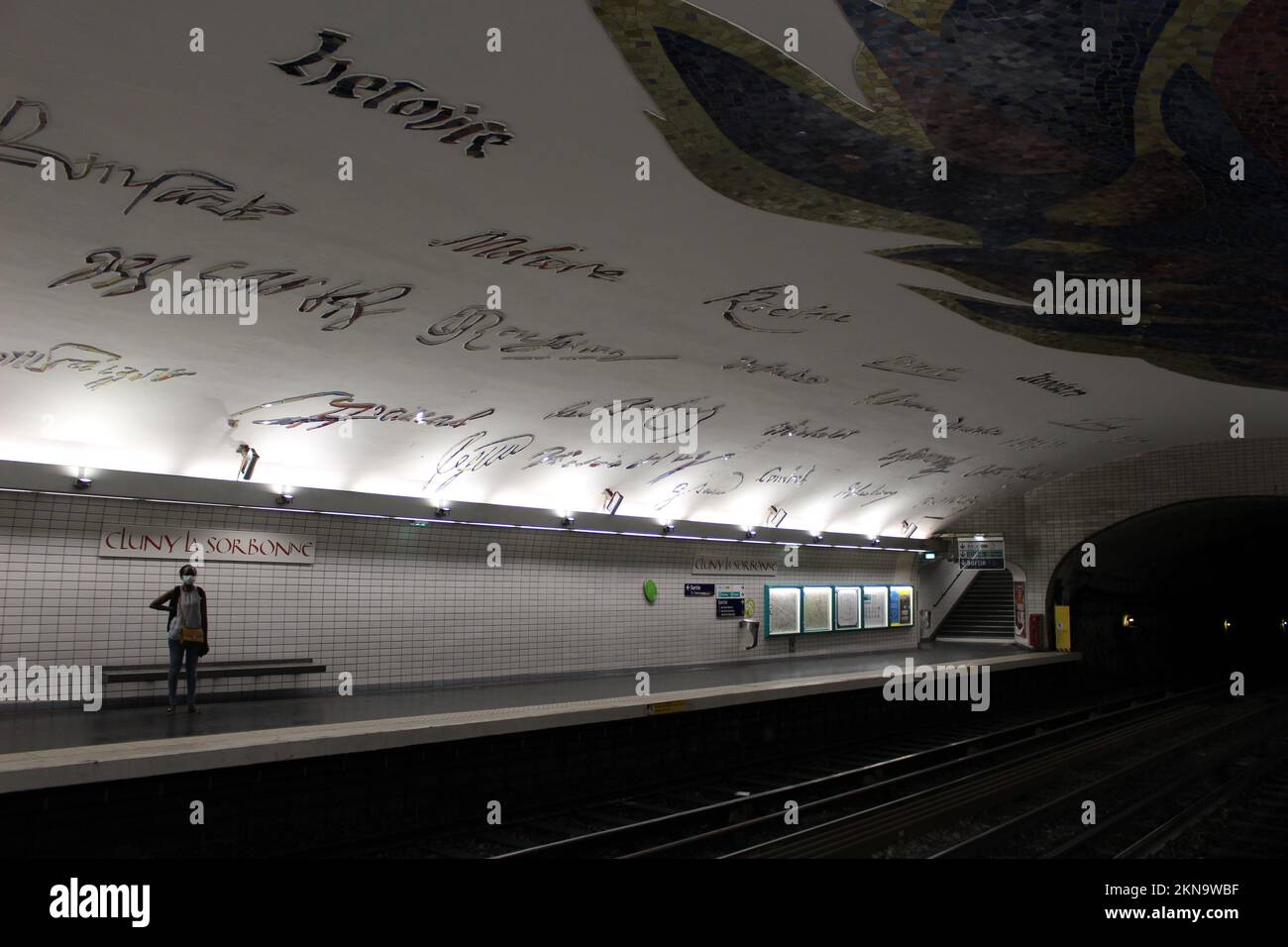 Eine Person, die allein an einer U-Bahn-Station in Paris auf den Zug wartet - Haltestelle Cluny-La Sorbonne Stockfoto