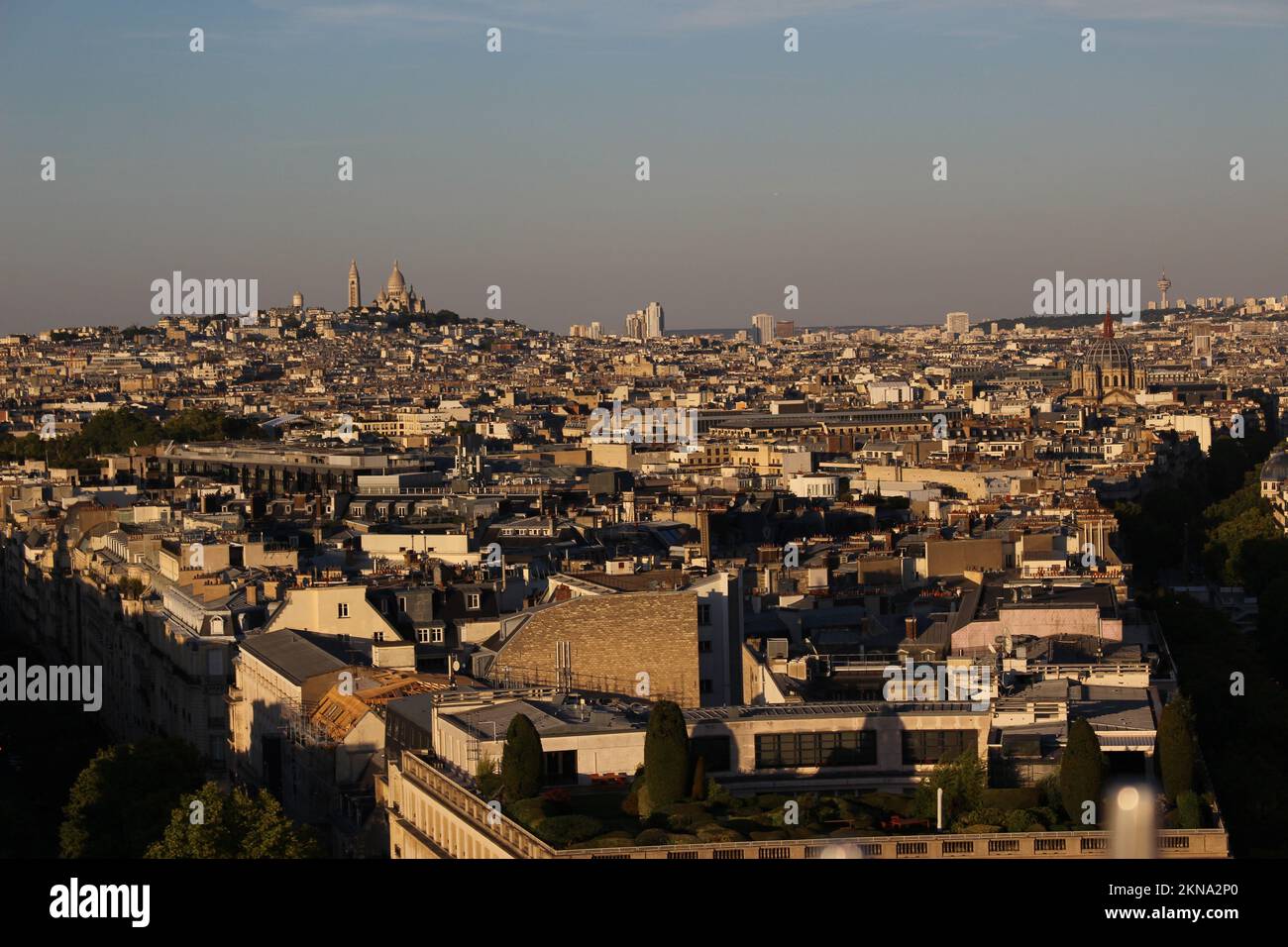 Blick auf Sacre Coeur und Paris vom Arc de Triomphe bei Sonnenuntergang mit sichtbarer Luftverschmutzung an klaren Abenden (Paris, Frankreich). Smoggy Skyline Stockfoto