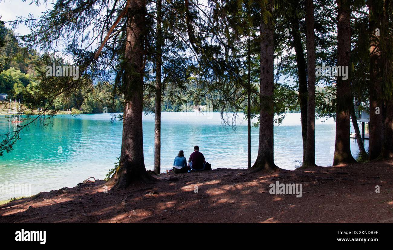 Ein Paar am Ufer des Bled Sees neben Bäumen in Slowenien Stockfoto