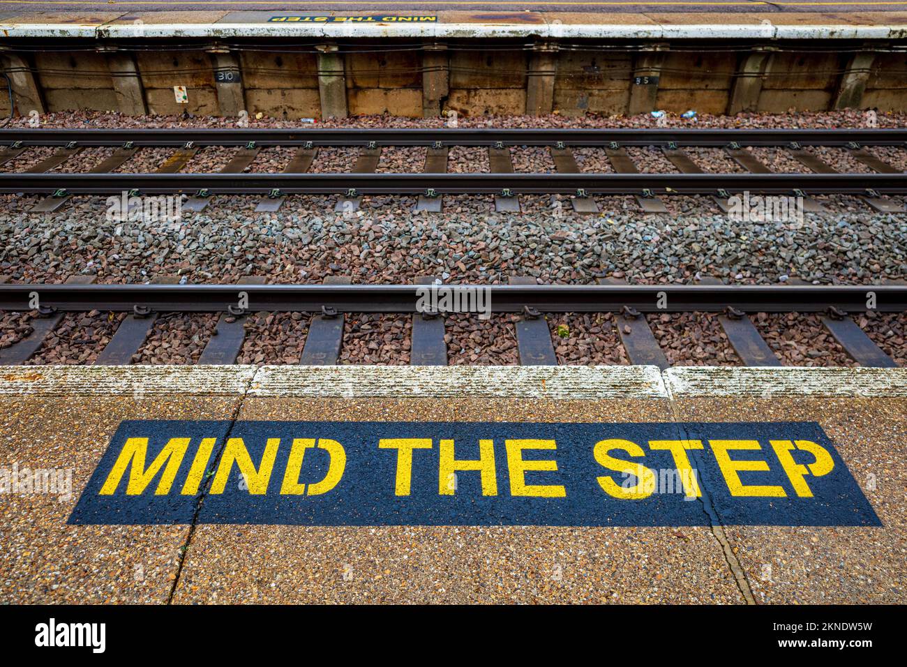 Beachten Sie das Trittschild auf einer britischen Bahnhofsplattform. Sicherheitsschild Bahnhofsplattform. Stockfoto
