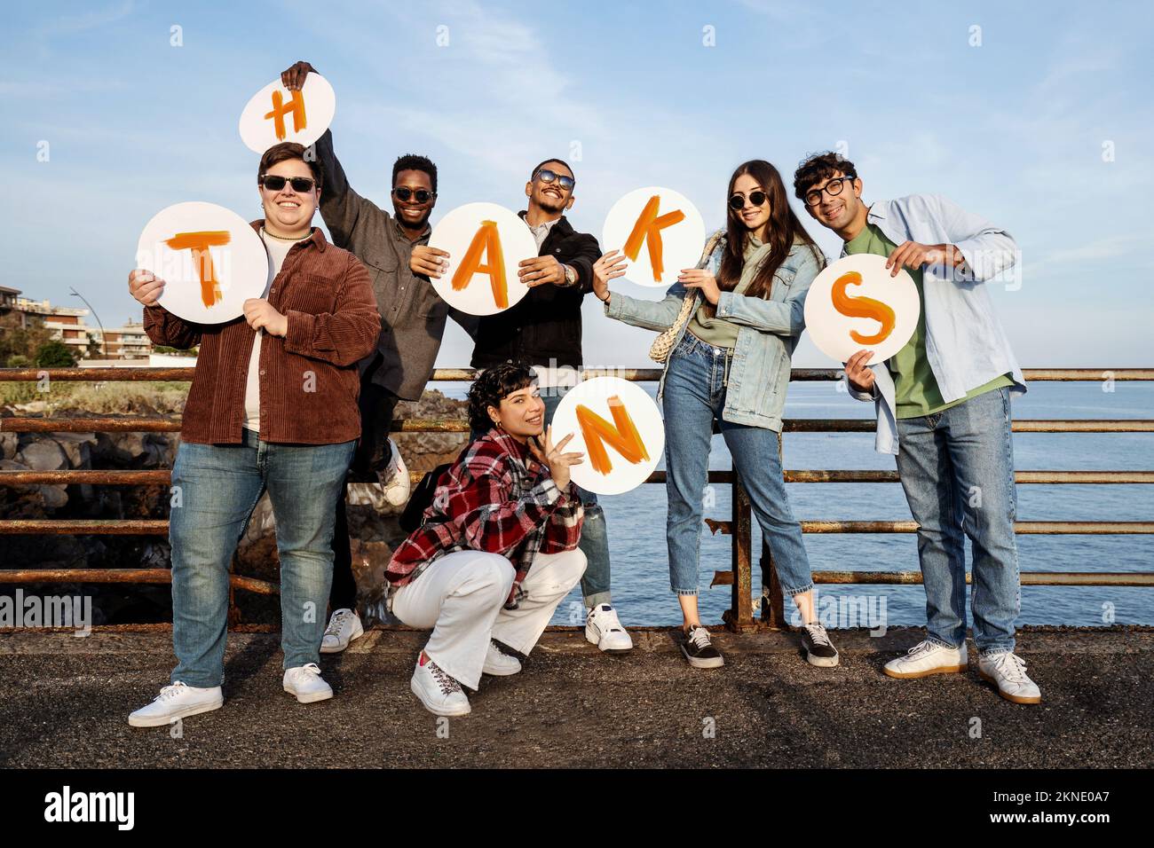 Das Porträt einer positiven Gruppe multiethnischer Jugendlicher vermittelt eine Dankesbotschaft mit dem Wort "danke", handgeschrieben in Großbuchstaben Stockfoto