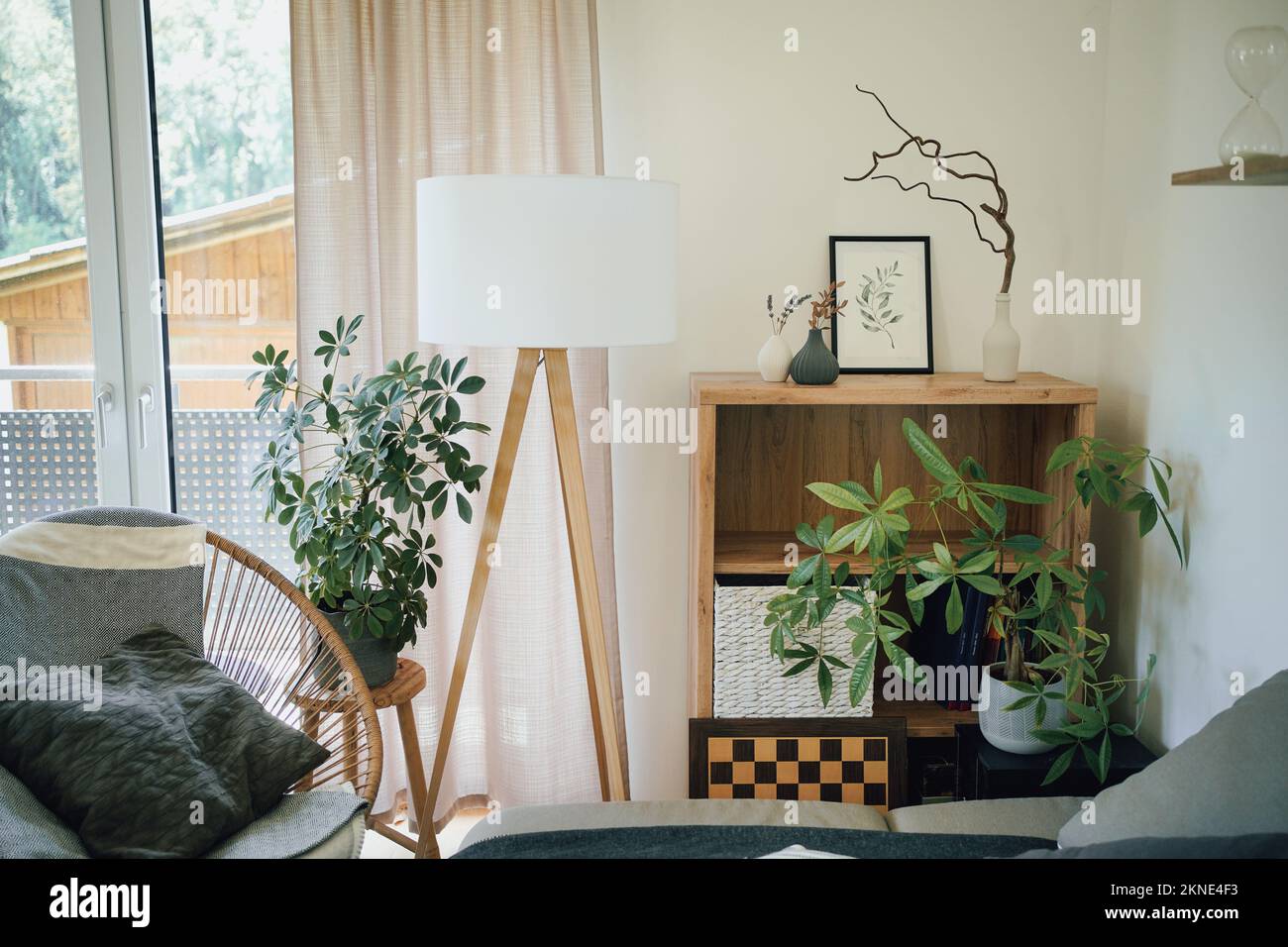 Moderne Einrichtung in natürlichen Farben mit Stativlampe, Pflanzen und Möbeln. Stockfoto