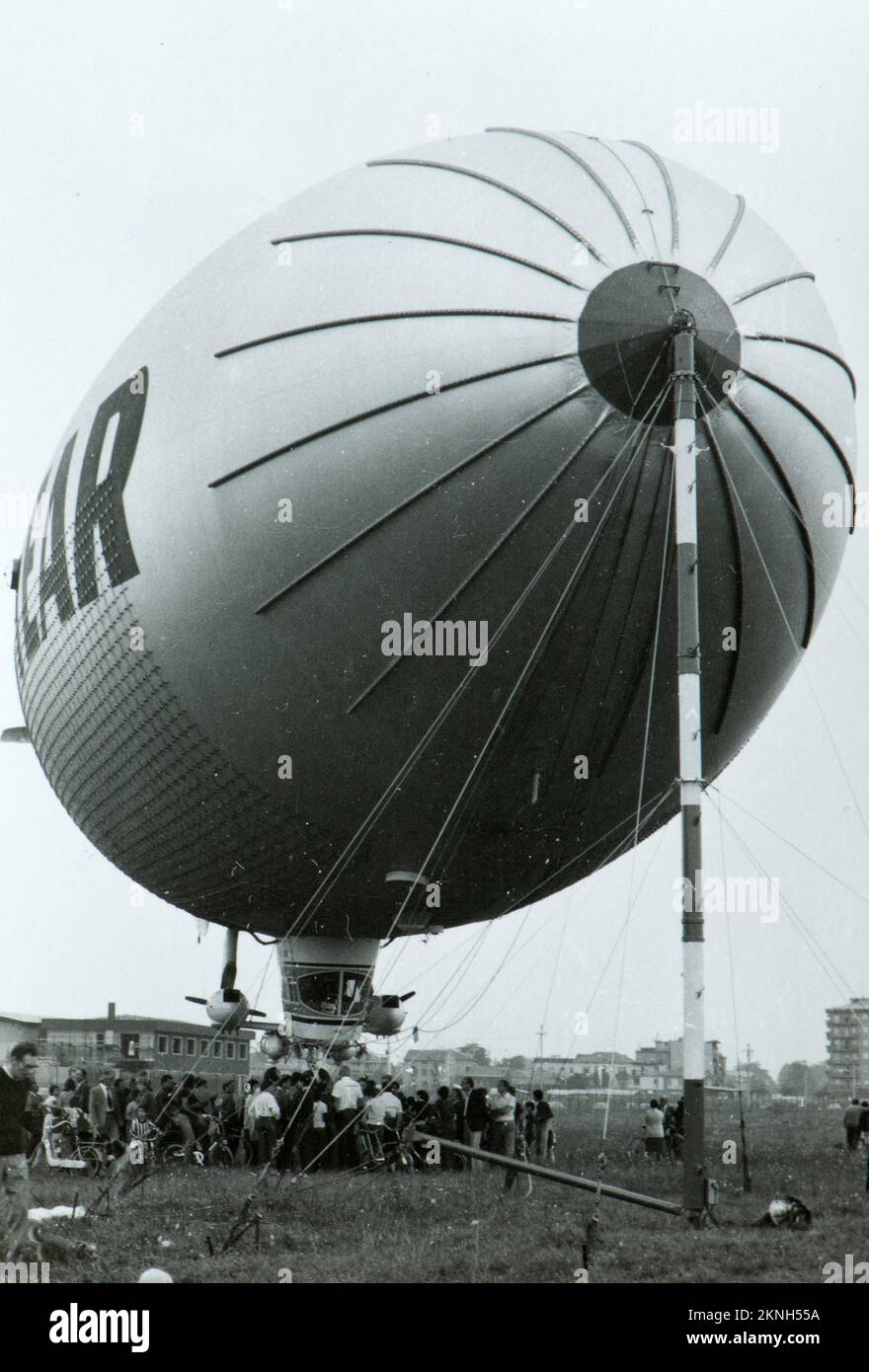Ein Luftschiff des Good Year, das von einer großen Anzahl von Menschen, die wahrscheinlich um Mailand herum in den späten Achtzigerjahren, an Land gezogen und bewundert wurde. Stockfoto