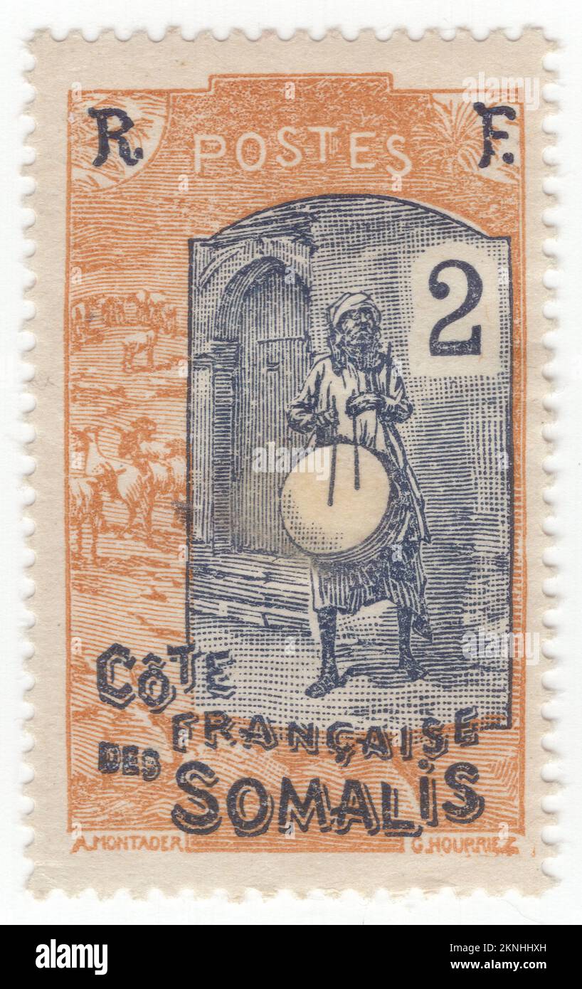 FRANZÖSISCHE SOMALISCHE KÜSTE DSCHIBUTI - 1915: Eine 2 centimeі Ocker- und Indigo-Briefmarke, die den einheimischen Schlagzeuger darstellt. Szene des normalen Lebens in dieser Gegend - ein Mann in traditioneller einheimischer Kleidung spielt eine große Trommel vor der Tür des Gebäudes. Er hat einen Turban auf dem Kopf, und Ziegen laufen neben ihm Stockfoto