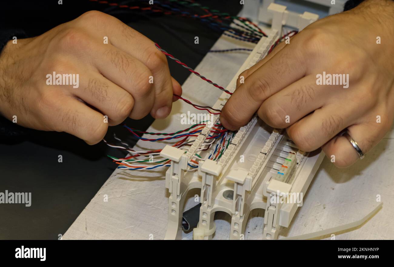 Hands-at-Work in der Netzwerkverkabelung in einem informationstechnischen Unterrichtsraum Stockfoto