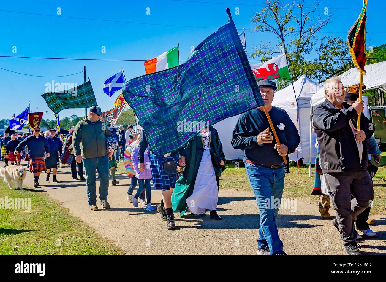 Bei der Parade der Clan-Tartane beim alljährlichen Celtic Music Festival und den Scottish Highland Games in Gulfport, Mississippi, tragen die Menschen Tartane mit sich. Stockfoto