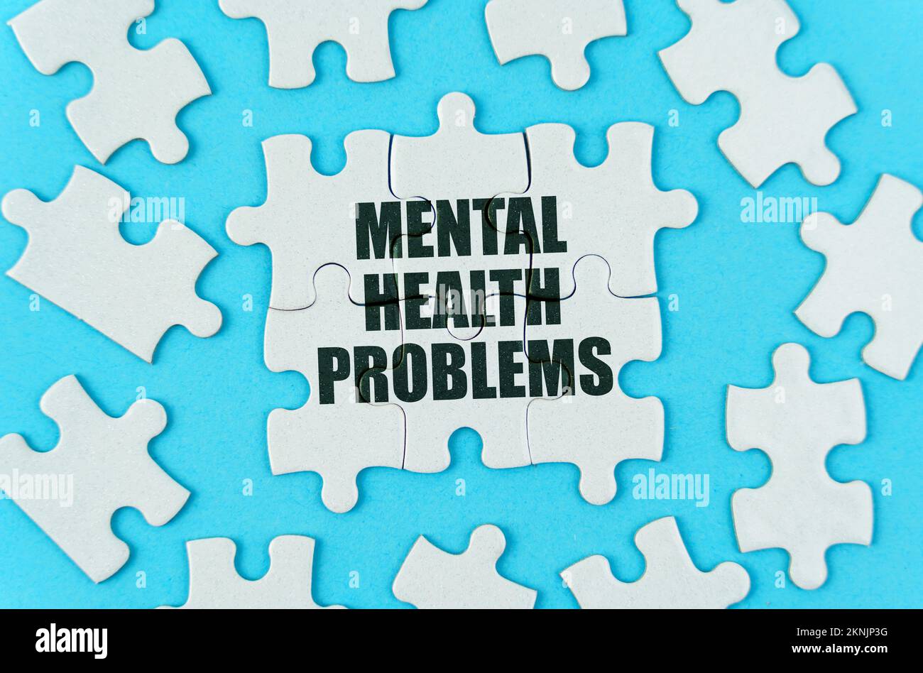Medizinisches Konzept. Auf blauem Hintergrund sind weiße Puzzles mit der Inschrift - psychische Gesundheitsprobleme Stockfoto