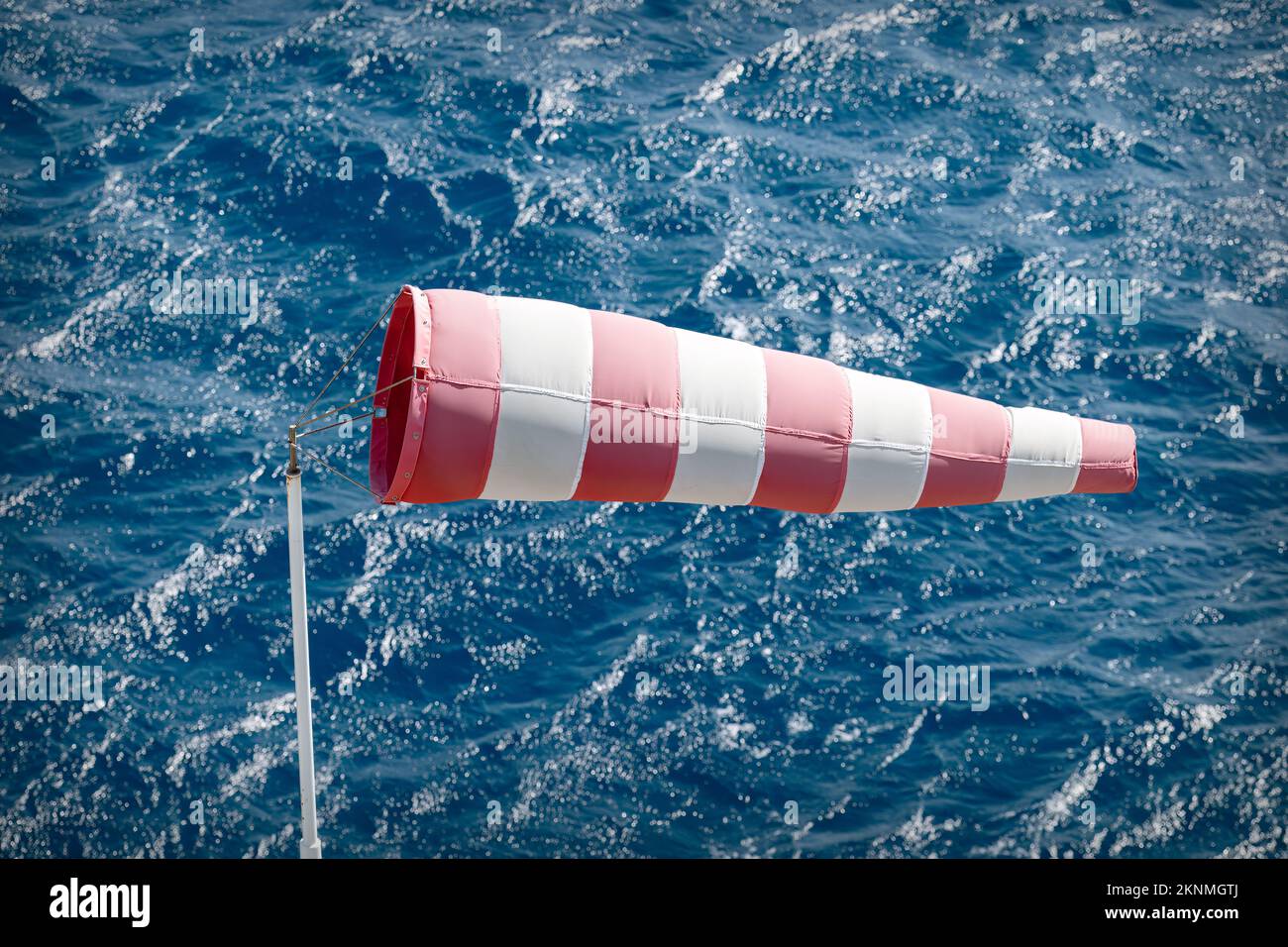Windsocke mit turbulentem Meer im Hintergrund. Stockfoto