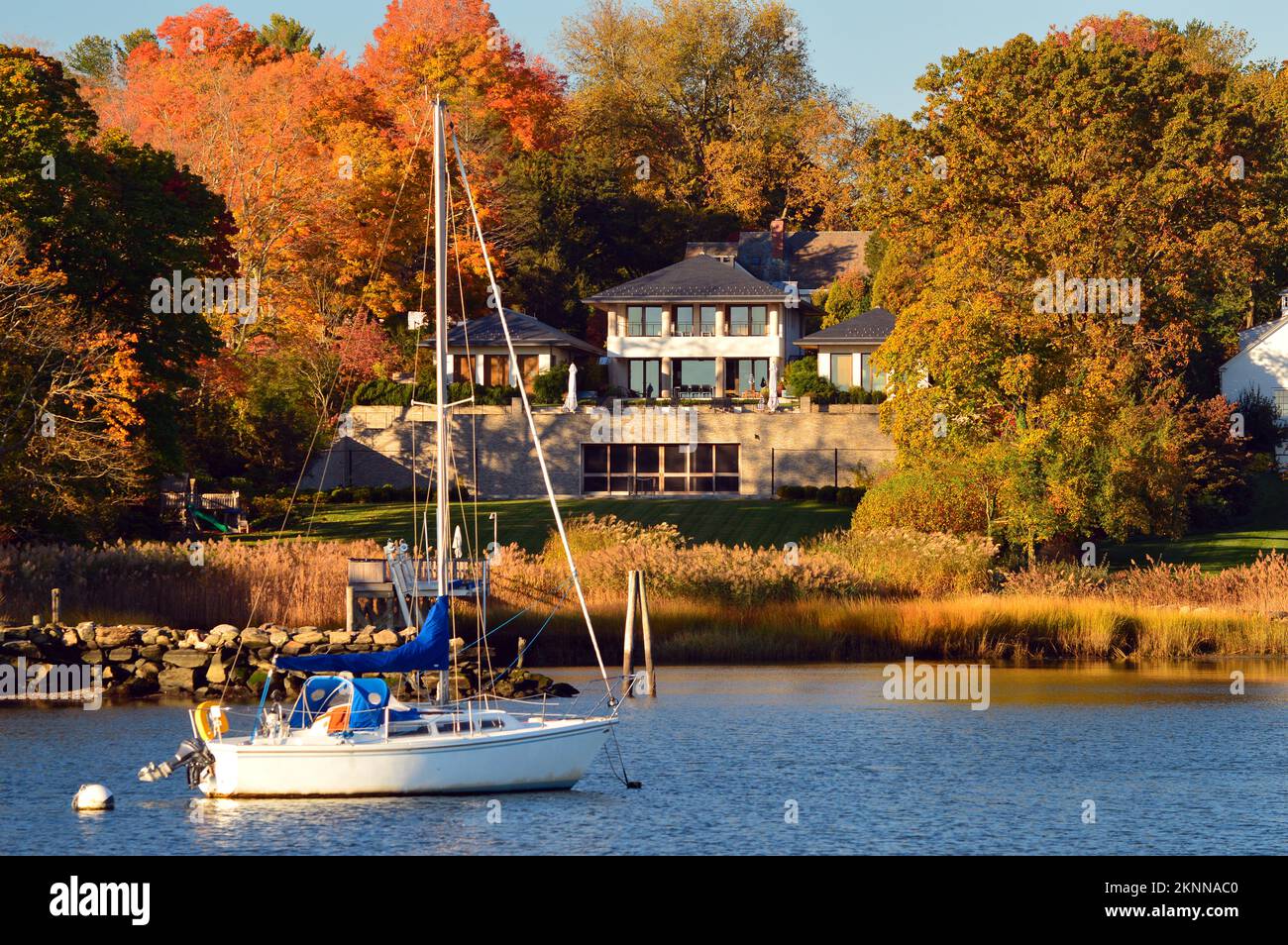 Ein Segelboot liegt vor einer Ufervilla in Greenwich, Connecticut, vor Anker Stockfoto