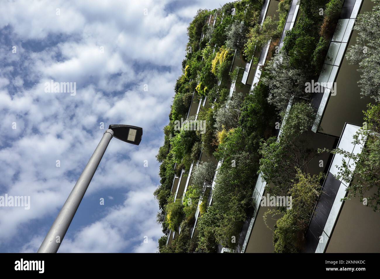 Mailand, Italien - 26. Juni 2022: Nachhaltiges Gebäude mit Straßenlampe und blauem Himmel mit Wolken im Viertel Porta Nuova. Unter Ansichtsarchitektur. Stockfoto