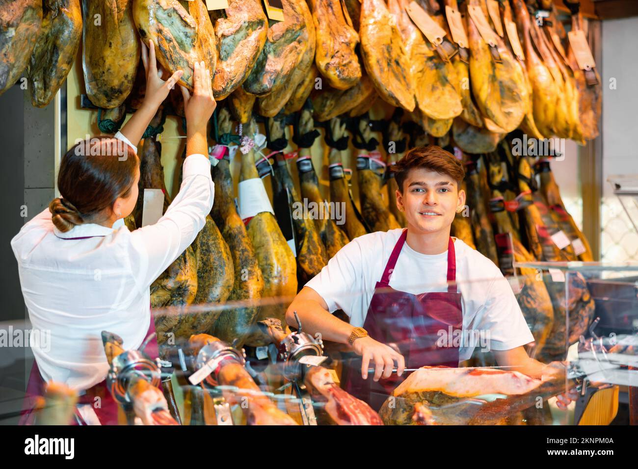 Ein junges Paar arbeitet zusammen in der Metzgerei - sie schneiden traditionellen spanischen Pyjon Stockfoto
