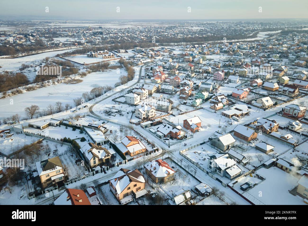 Luftaufnahme von Wohnhäusern mit schneebedeckten Dächern im ländlichen Stadtgebiet in Vororten im Winter Stockfoto