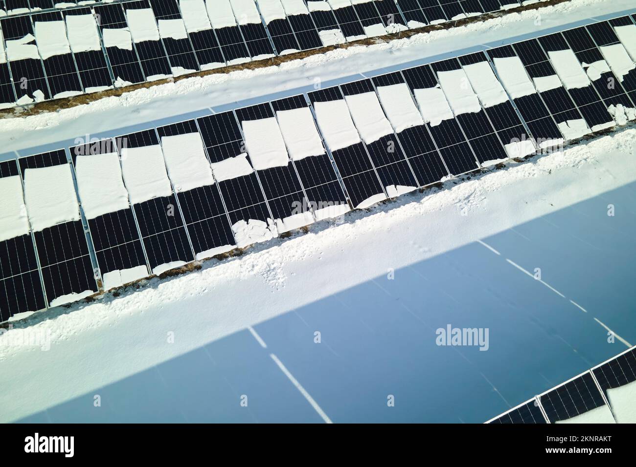 Luftaufnahme des Schneeschmelzens von überdachten Solarpaneelen in einem nachhaltigen Kraftwerk zur Erzeugung sauberer elektrischer Energie. Niedrig Stockfoto