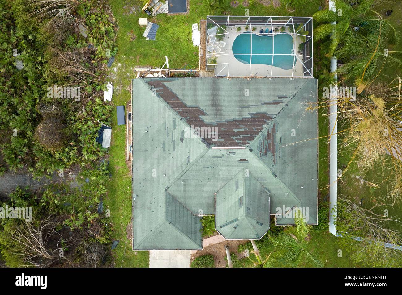Beschädigtes Hausdach mit fehlenden Schindeln nach Hurrikan Ian in Florida. Folgen einer Naturkatastrophe Stockfoto