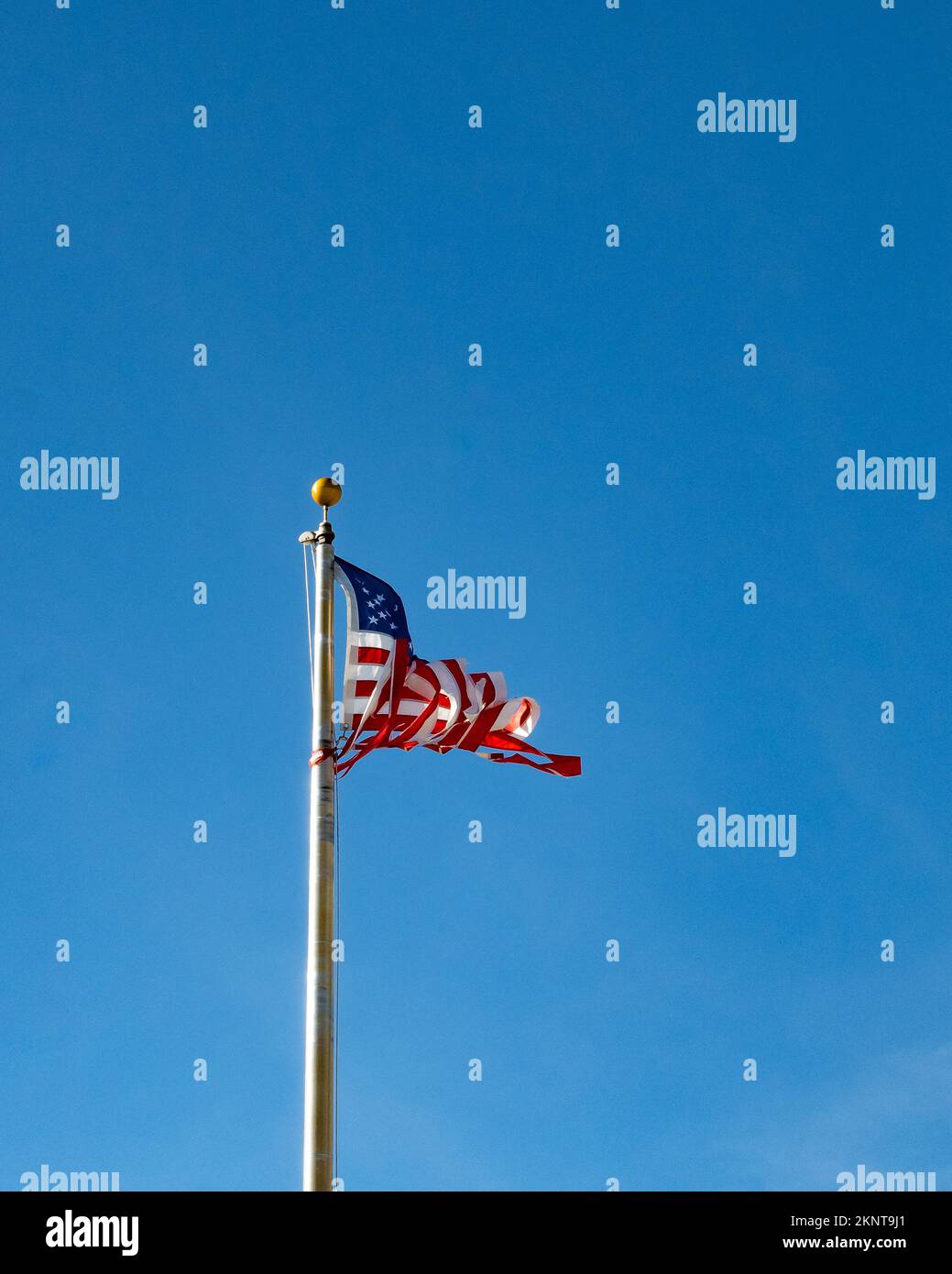 Twisted und zerrissenen amerikanischen Flagge auf dem tiefen blauen Hintergrund, symbolisch für eine Nation zerrissen wird abgesehen. Stockfoto