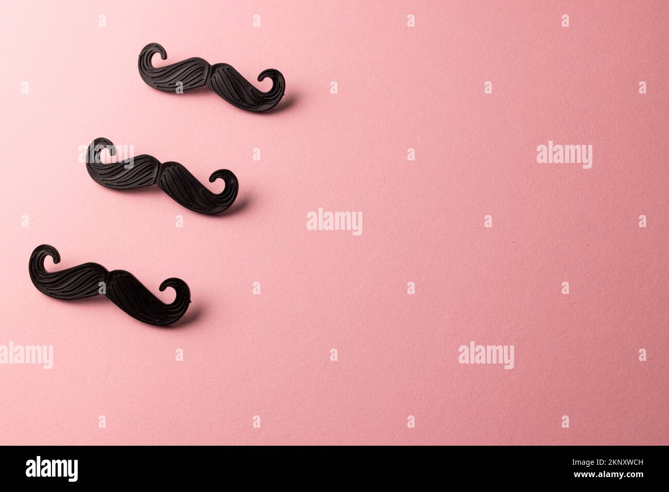 Komposition gefälschter Schnurrbärte auf pinkfarbenem Hintergrund mit Kopierraum Stockfoto