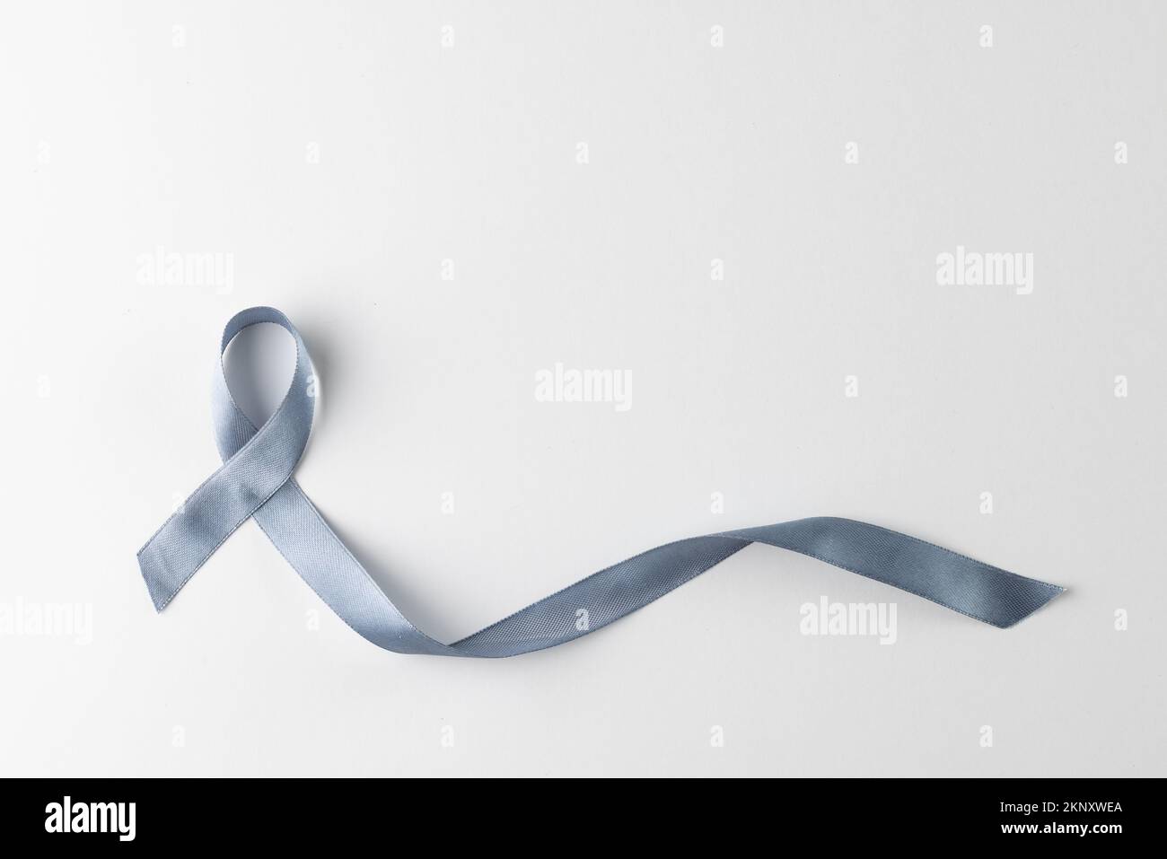 Zusammensetzung des grauen Bands für das Krebsbewusstsein, auf weißem Hintergrund mit Kopierbereich Stockfoto