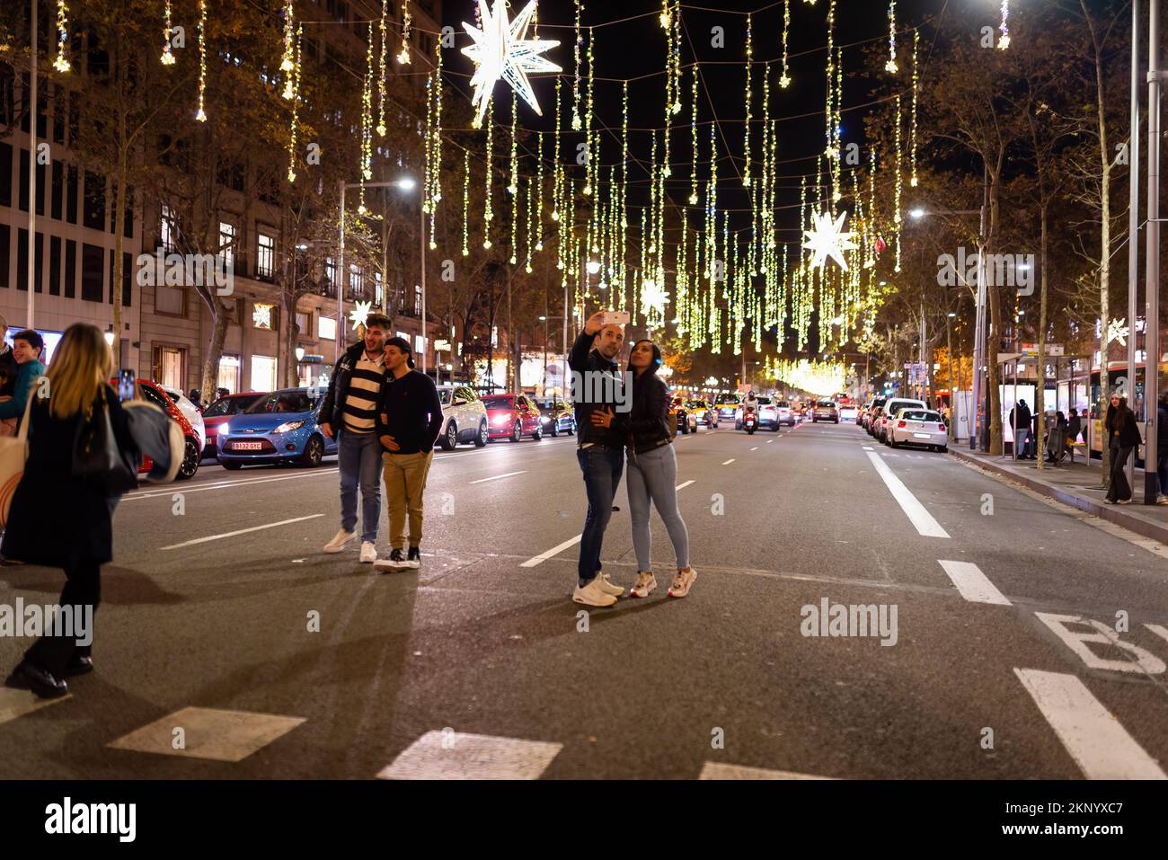 Barcelona, Spanien. 26.. November 2022. Die Leute machen Fotos unter den Weihnachtslichtern in der Passeig de gracia Straße. Die Stadtverwaltung von Barcelona hat die Anzahl der Lichter und die Beleuchtungszeiten aufgrund der durch den Krieg zwischen Russland und der Ukraine verursachten erhöhten Energiekosten reduziert. Kredit: SOPA Images Limited/Alamy Live News Stockfoto