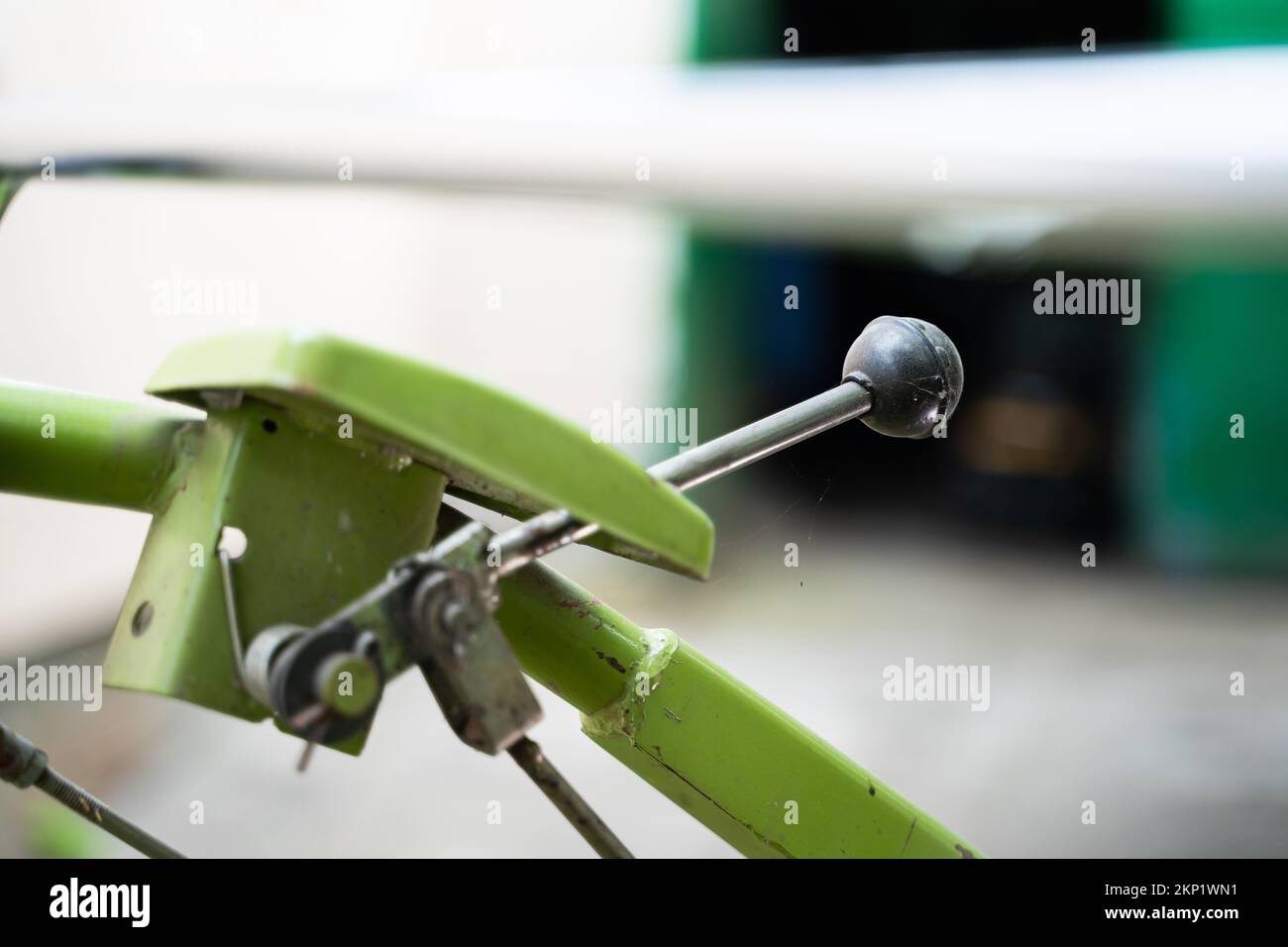 Der Bedienhebel eines hinter dem Traktor stehenden Traktors ist in Nahaufnahme auf einem unscharfen Hintergrund zu sehen. Bedienelemente von Landmaschinen. Stockfoto
