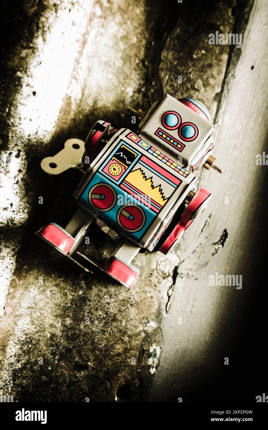 Kreatives Grunge-Design auf einem kleinen mechanischen Roboter auf verwittertem Metallhintergrund. Kybernetischer Droid der achtziger Jahre Stockfoto