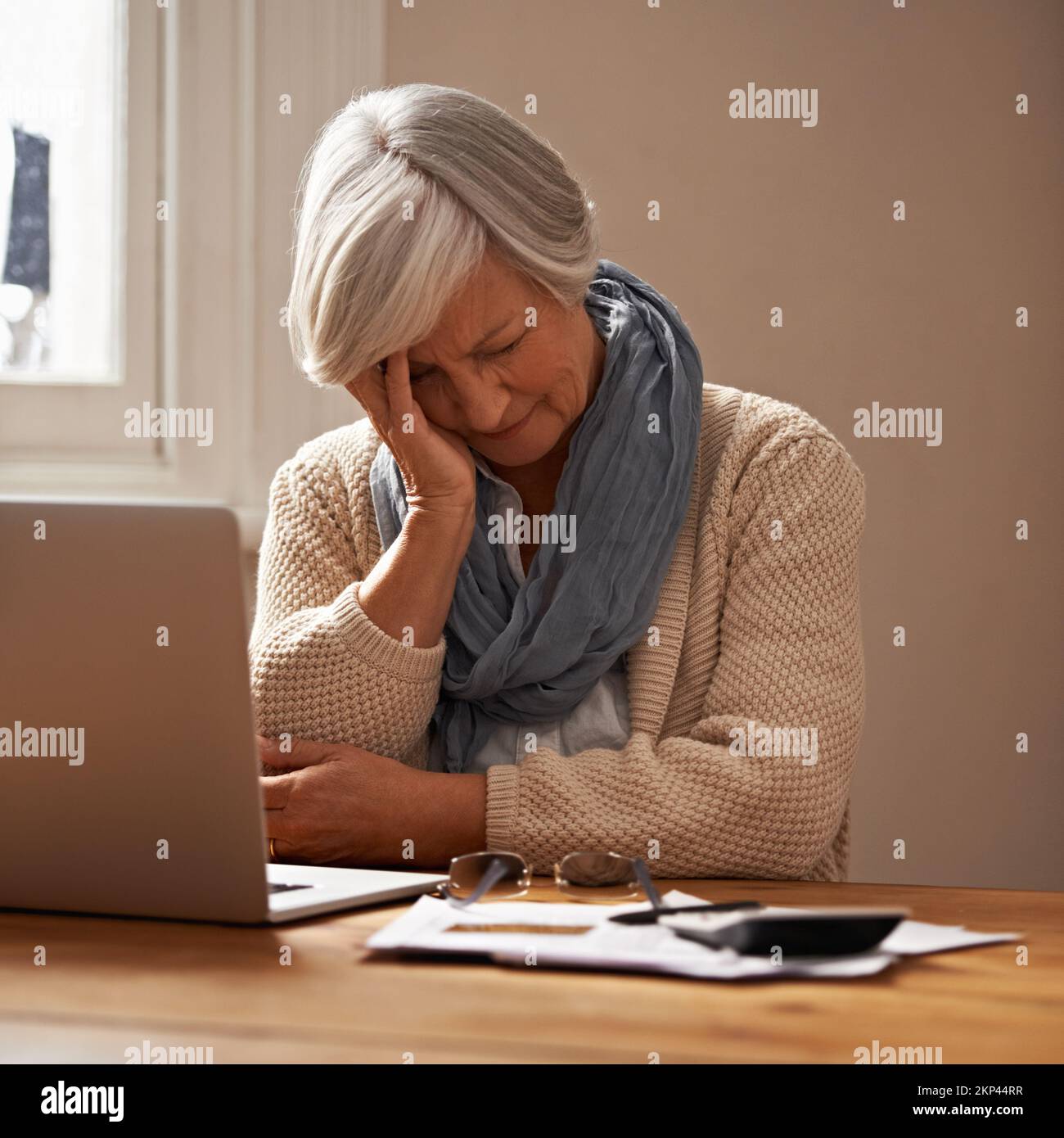 Die Sorge um die Pensionskasse...eine schamlos vor ihrem Laptop sitzende Frau sieht gestresst und besorgt aus. Stockfoto