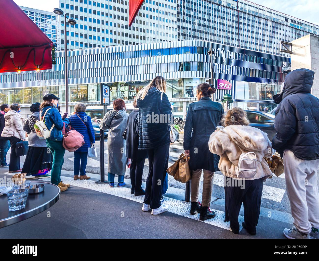 Fußgänger warten darauf, die geschäftige Stadtstraße zu überqueren - Montparnasse, Paris, Frankreich. Stockfoto