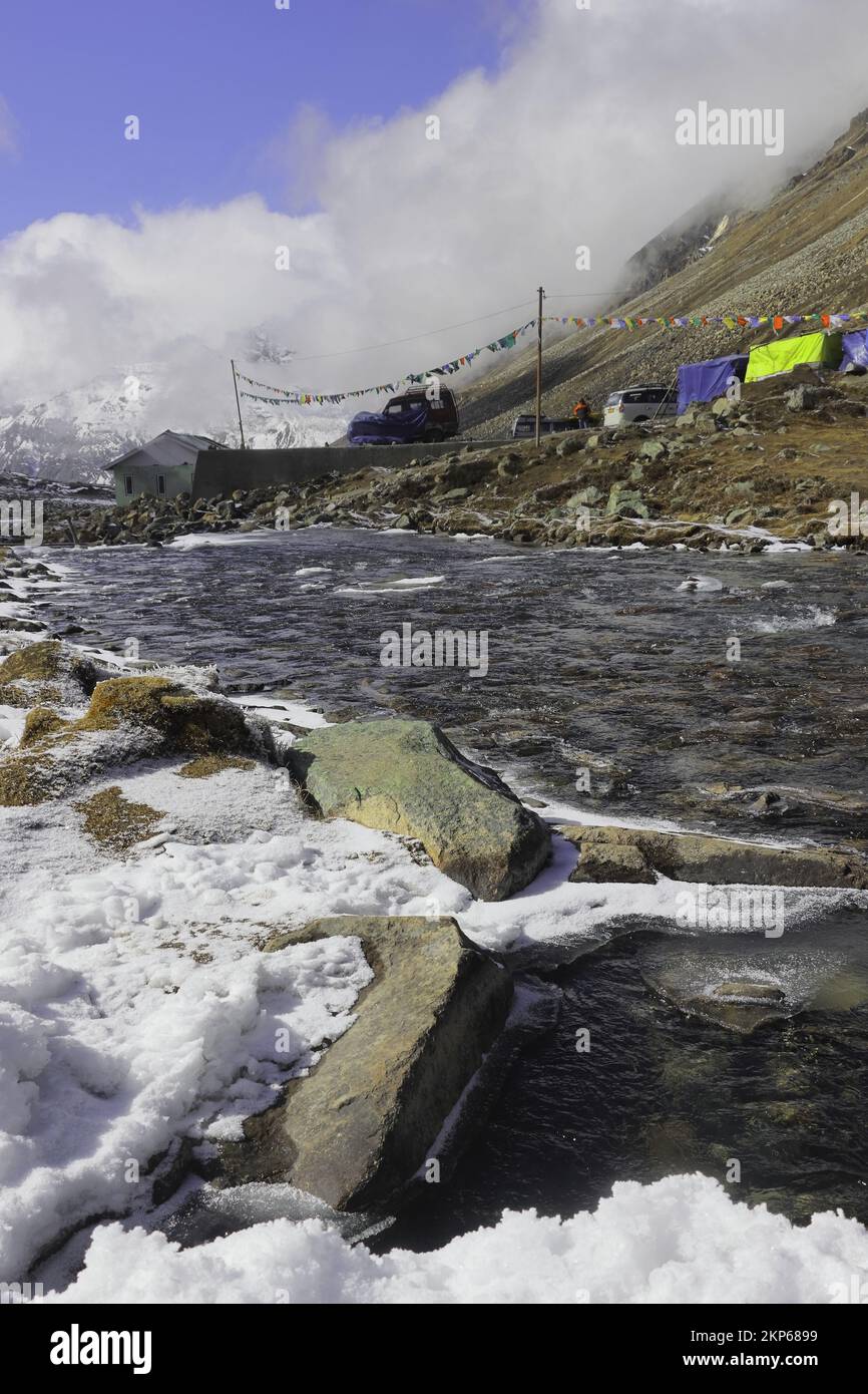 Gefrorener Bergbach, der durch das malerische Alpental am Yumesodong oder Zero Point fließt, das wunderschöne himalaya-Tal in sikkim, indien Stockfoto