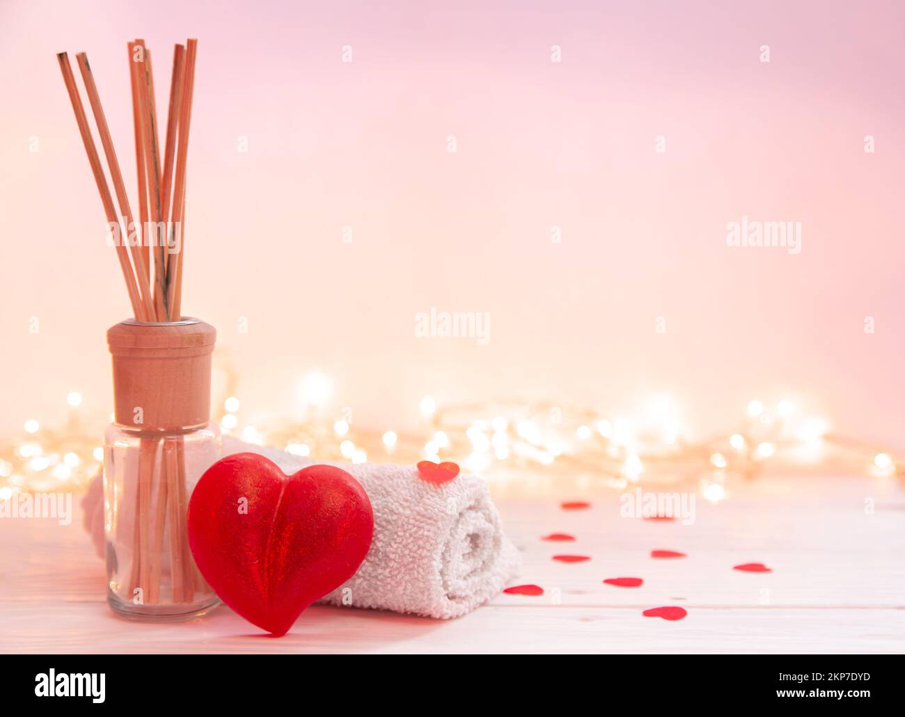 Spa-Zusammensetzung mit Räucherstäbchen, Handtuch und herzförmiger Seife. Stockfoto