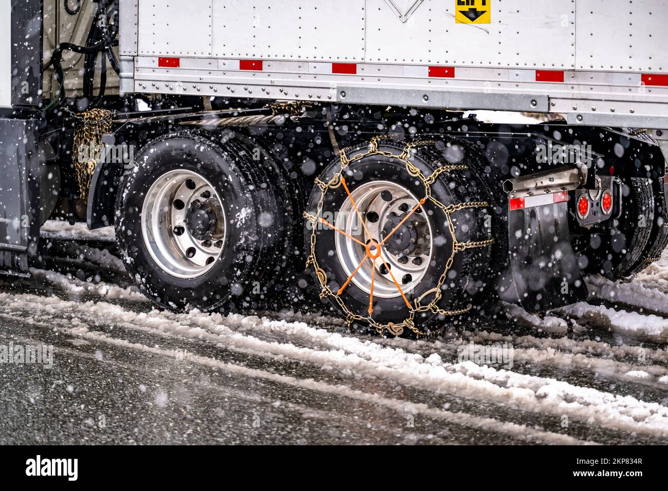 Erfahrener Lkw-Fahrer legt Ketten auf die Räder des großen Lkw mit  Auflieger, um während eines Schneesturms sicher auf einer Winterautobahn zu  fahren Stockfotografie - Alamy