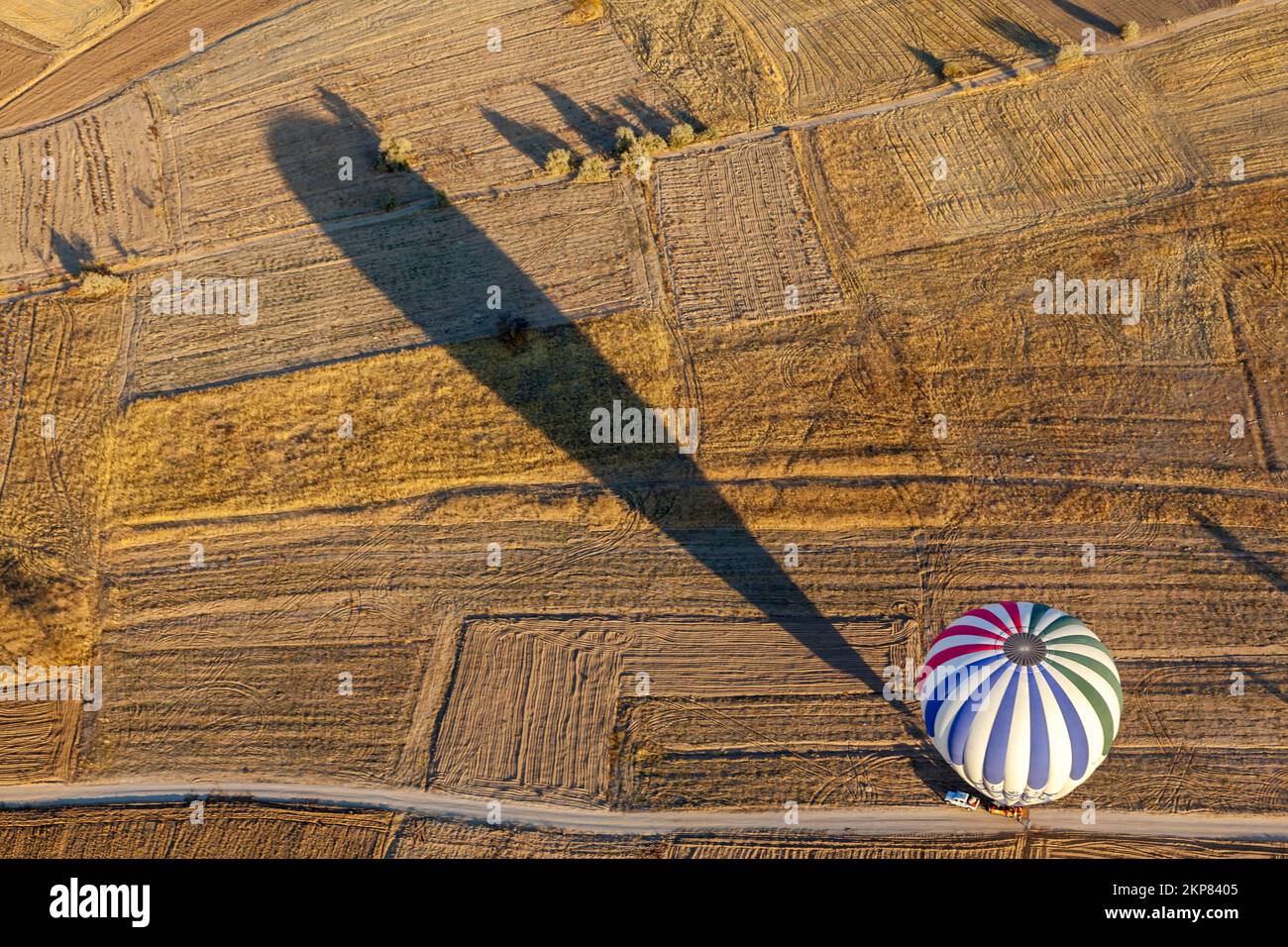 Heißluftballon über Feldern, Göreme-Nationalpark, Kappadokien, Zentralanatolien, Anatolien, Türkei, Asien Stockfoto