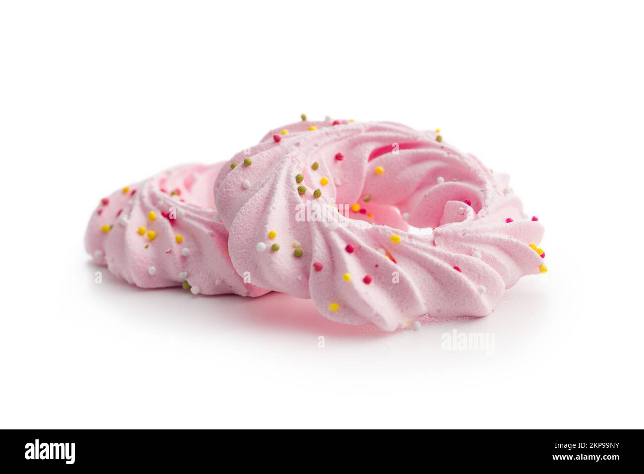 Rosafarbene, süße Baiser mit Streuseln auf weißem Hintergrund. Stockfoto