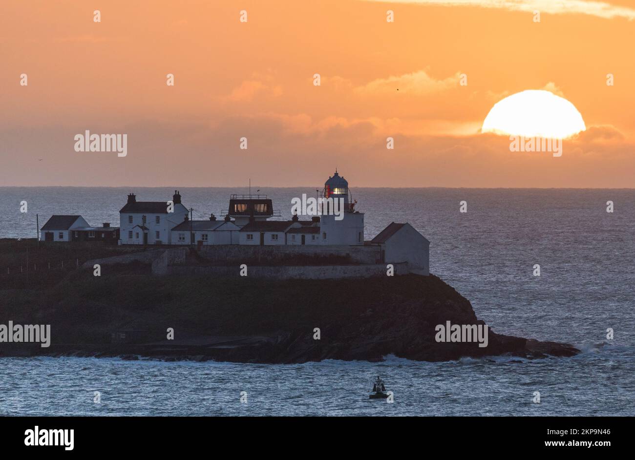 Roches Point, Cork, Irland. 28.. November 2022. Die Sonne steigt hinter Wolken am Roches Point Lighthouse in Cork Harbour, Co Cork, Irland. David Creedon/Alamy Live News Stockfoto